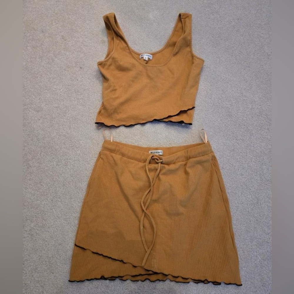 Strut your stuff in this fashionable gold skirt set with black trim